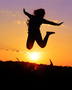 A Woman Jumping Into the Air Shadow in the Evening Shot