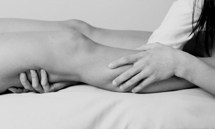 A Person Doing a Leg Massage in Black and White